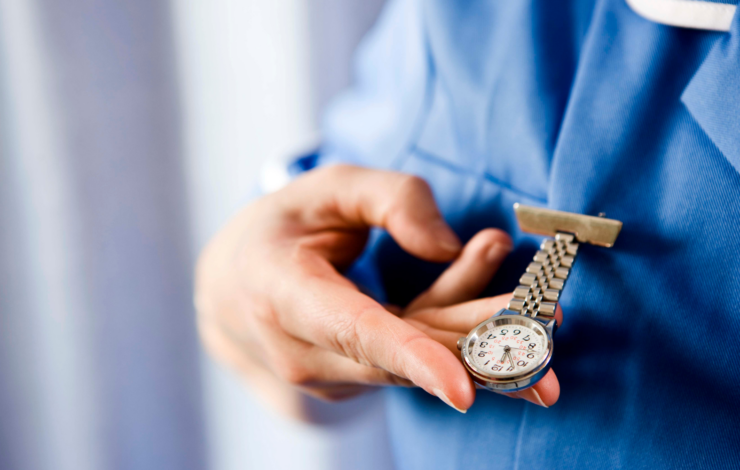 Person, die auf Schwestern-/Pflegeuhr guckt