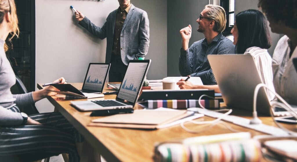 Mitarbeiter:innen tauschen sich bei Meeting aus