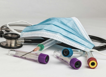 Mund-Nasen-Schutz liegt auf Stethoskop und weiteren Medizinprodukten