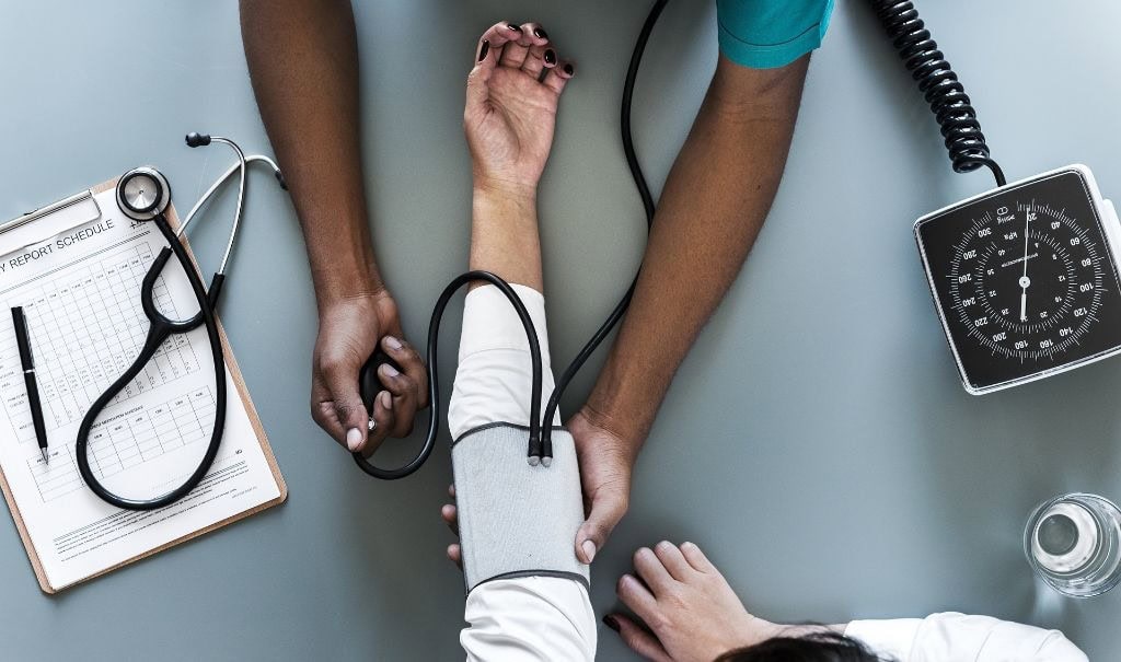 Eine medizinische Arbeitskraft misst den Blutdruck.