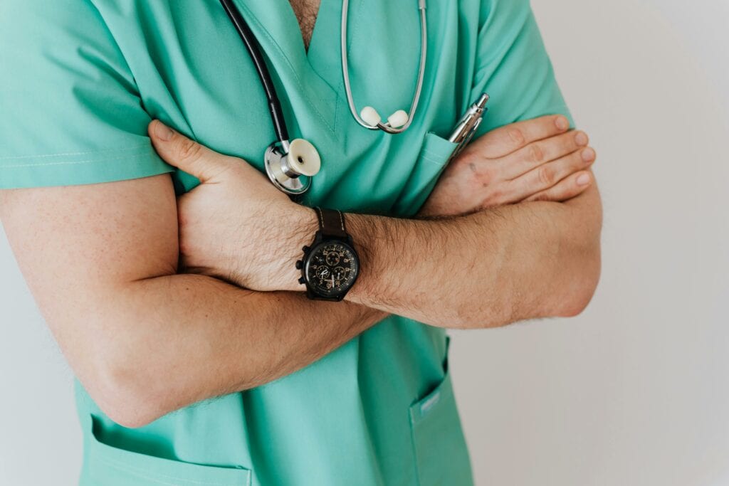 Ein medizinischer Angestellter in Arbeitskleidung, der eine Armbanduhr trägt.