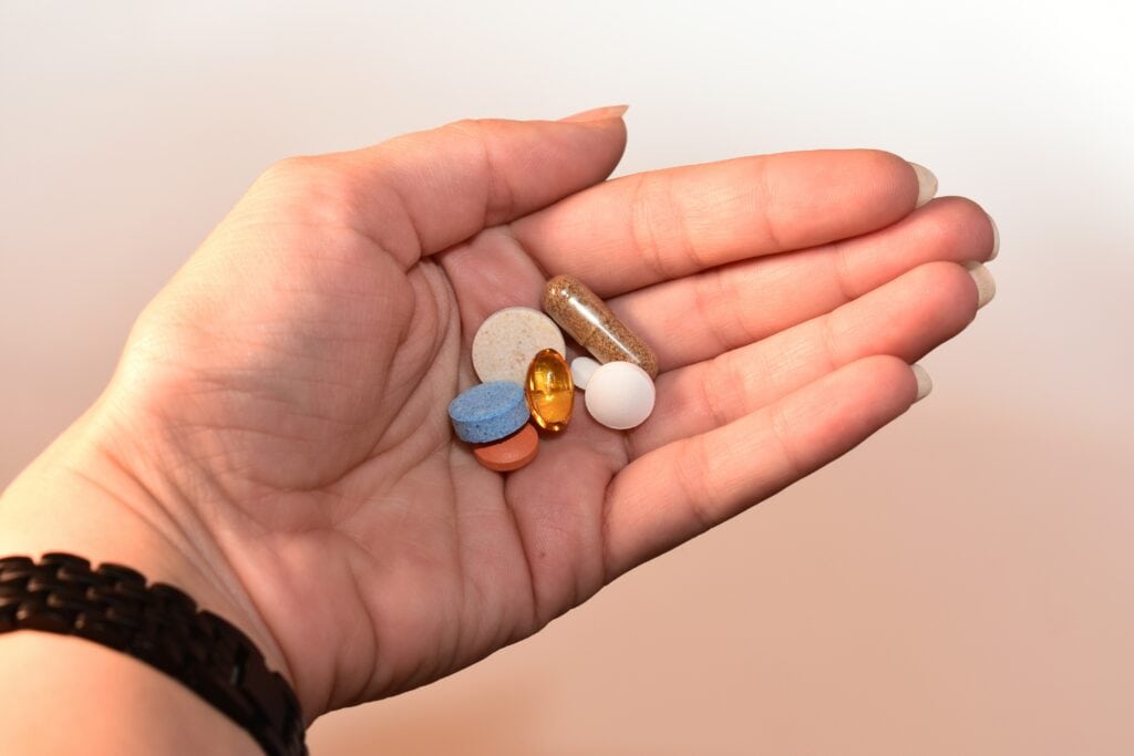 Verschiedene Tabletten in einer Handfläche.